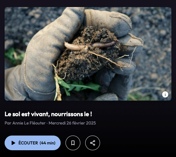 Main gantée tenant une motte de terre avec un ver de terre, symbole de la vie du sol et de l’agriculture régénérative.