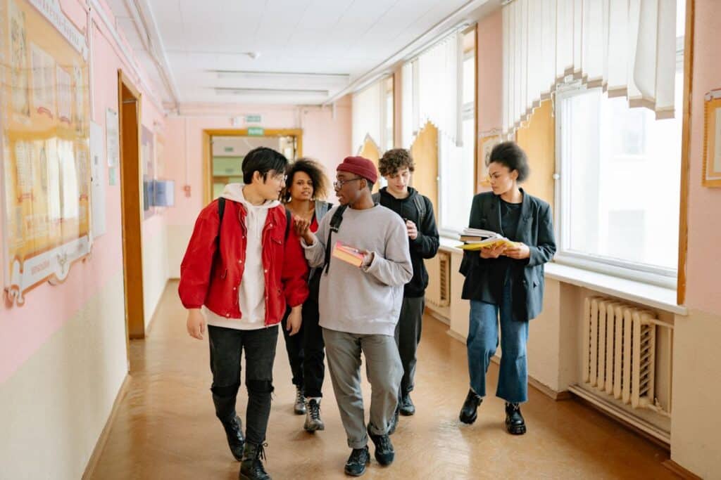 Un groupe diversifié d'étudiants universitaires marchant et conversant dans un couloir.